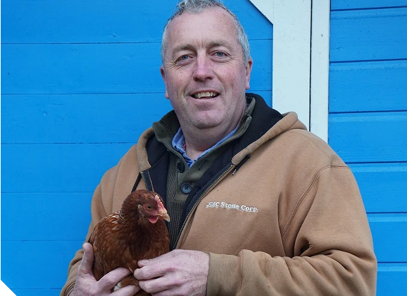 An image of Niall Rice holding one of his Chickens at Minnie Stays