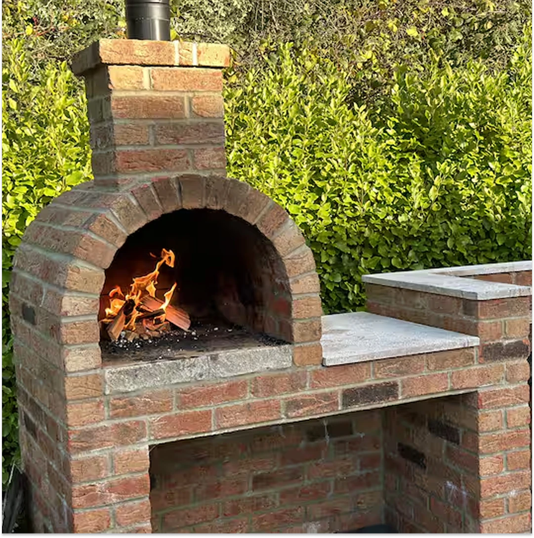 An image of a wood fire occurring inside the Brick Pizza Oven at Lily's Pink House