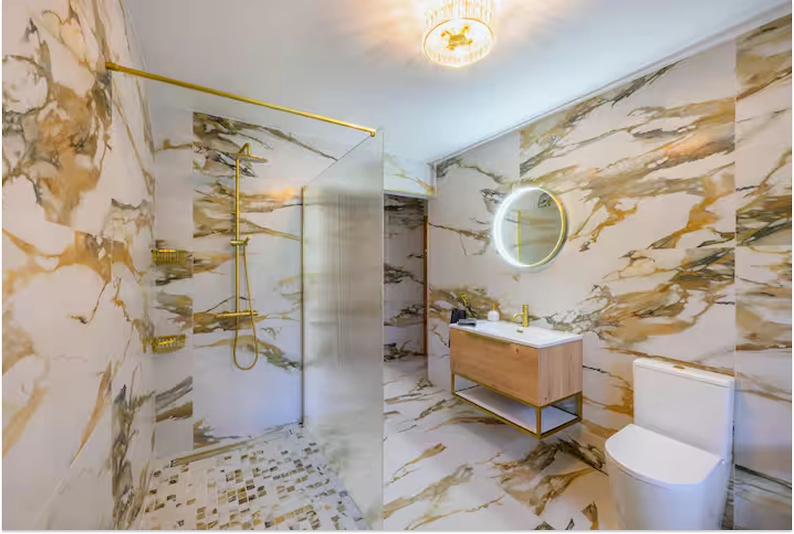 Image of Lily's Pink house bathroom showcasing the walk-in shower, with frosted glass privacy screen, toilet, and floating sink area.