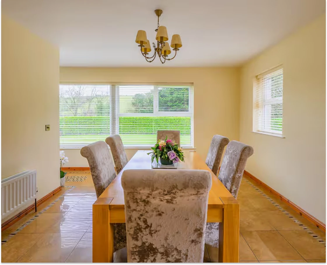 An image showcasing the large dining room with lots of large windows letting in a lot of natural light onto the marble tile floors.
