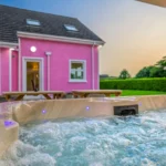 An image of the view from the hot tub at Lily's Pink House showcasing the sunset and back entrance into the house.