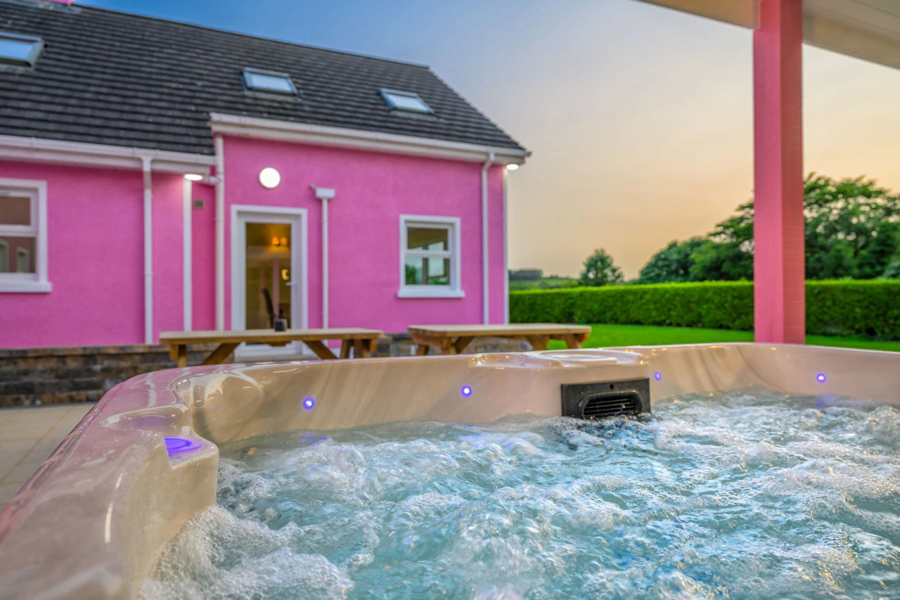An image of the view from the hot tub at Lily's Pink House showcasing the sunset and back entrance into the house.