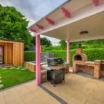 Lily's Pink House covered grilling area with outdoor brick pizza oven, outdoor grill area, plunge pool, and sauna