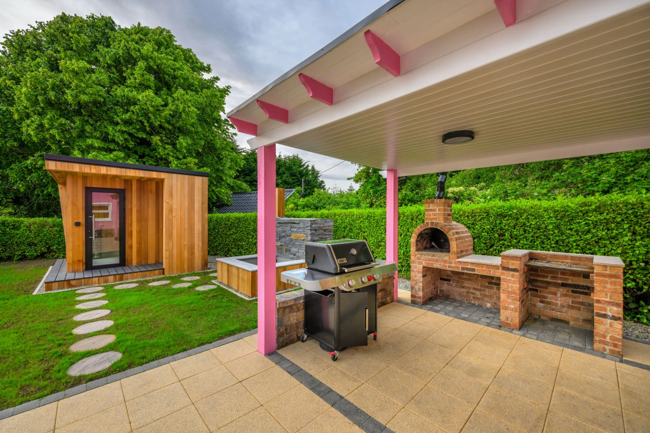 Lily's Pink House covered grilling area with outdoor brick pizza oven, outdoor grill area, plunge pool, and sauna