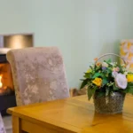 Image of a decorated table in Lily's pink house nearby the fireplace.